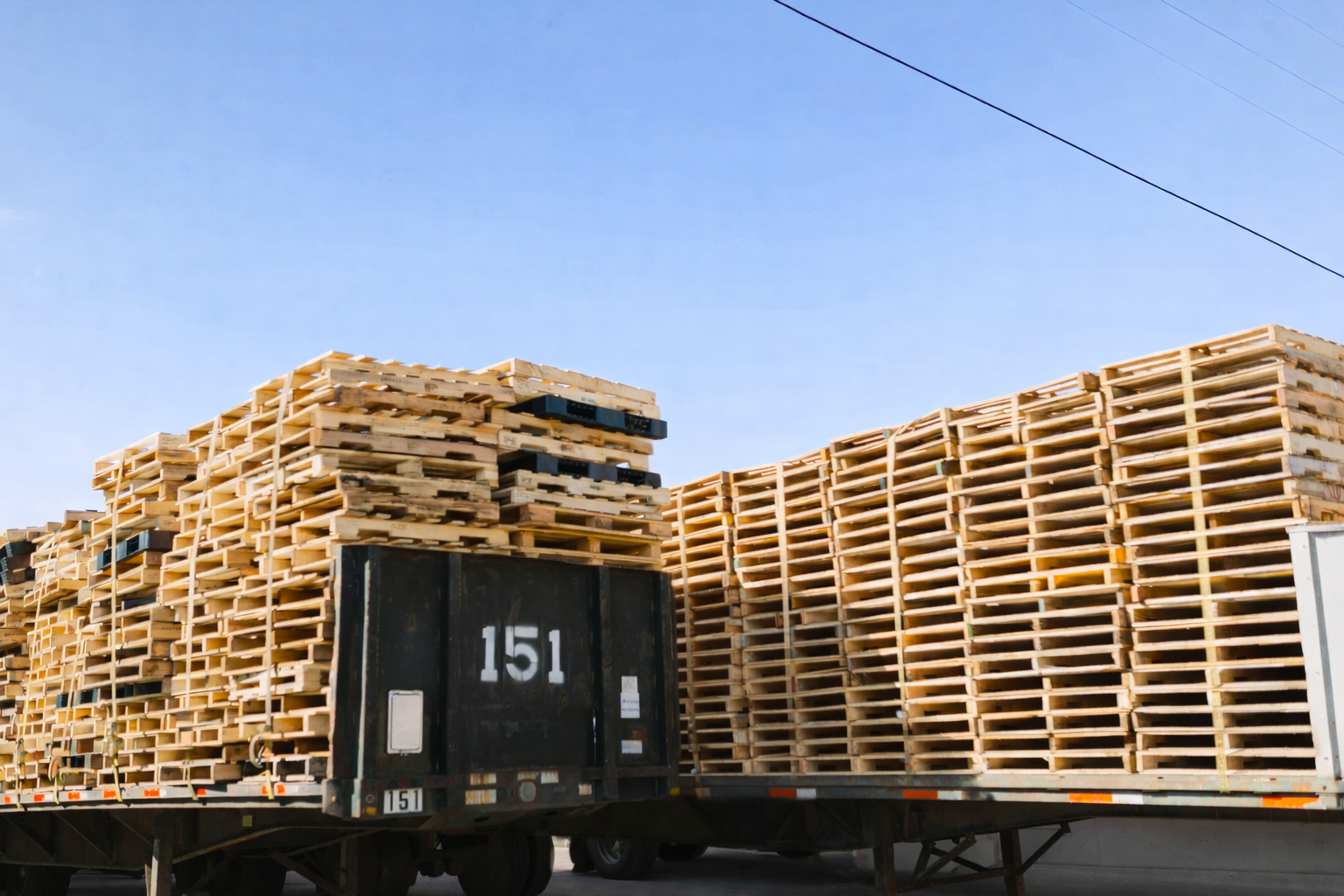 Flatbed trailers loaded with stacked pallets